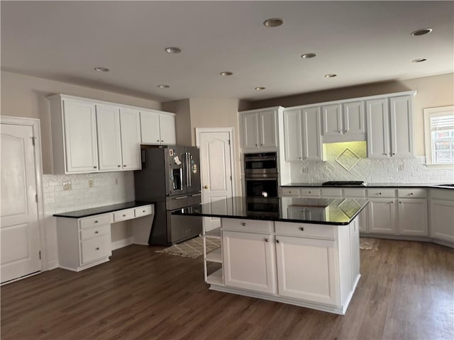 kitchen with dark countertops, white cabinets, dark wood-type flooring, and stainless steel appliances