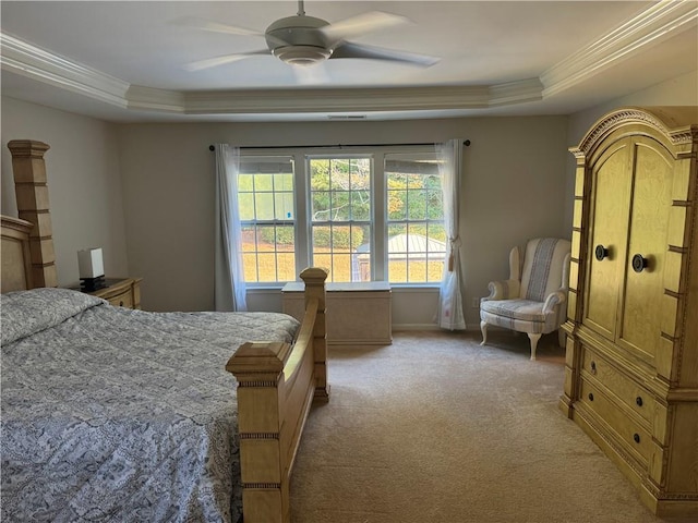 bedroom featuring a raised ceiling, ornamental molding, light colored carpet, and ceiling fan