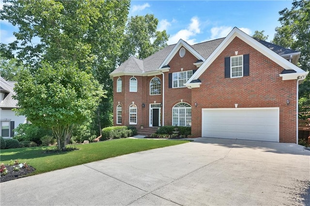 view of front of house with a front yard, brick siding, driveway, and an attached garage