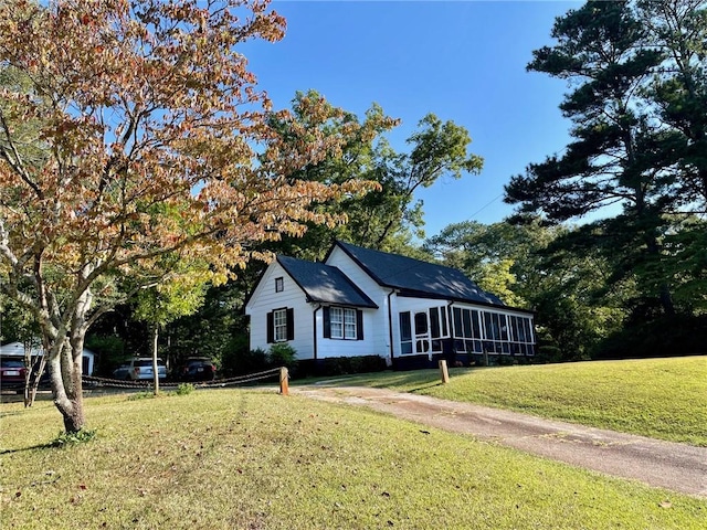 view of front of property with a sunroom and a front lawn