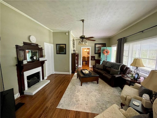 living room with ornamental molding, a textured ceiling, ceiling fan, and dark hardwood / wood-style flooring