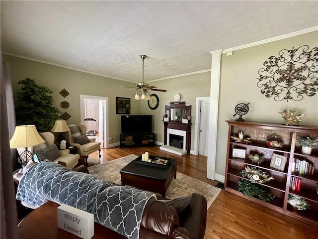 living room with wood-type flooring, crown molding, and ceiling fan