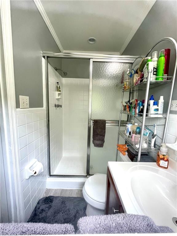 bathroom featuring tile walls, walk in shower, hardwood / wood-style floors, vanity, and toilet