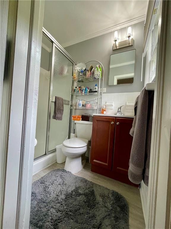 bathroom featuring walk in shower, ornamental molding, vanity, and toilet