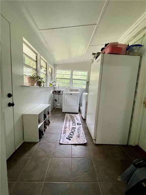 interior space with washer and clothes dryer and dark tile patterned flooring