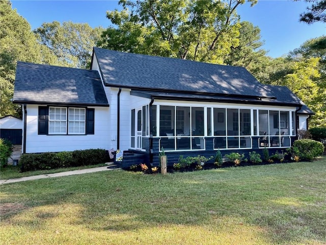 view of front of property featuring a sunroom and a front lawn