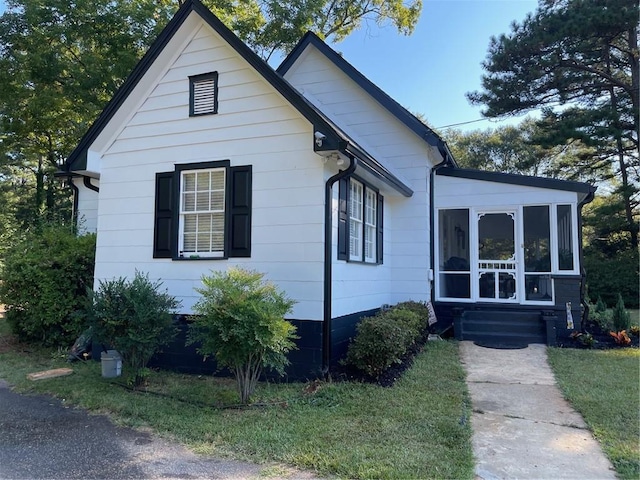 view of front of house with a front lawn and a sunroom