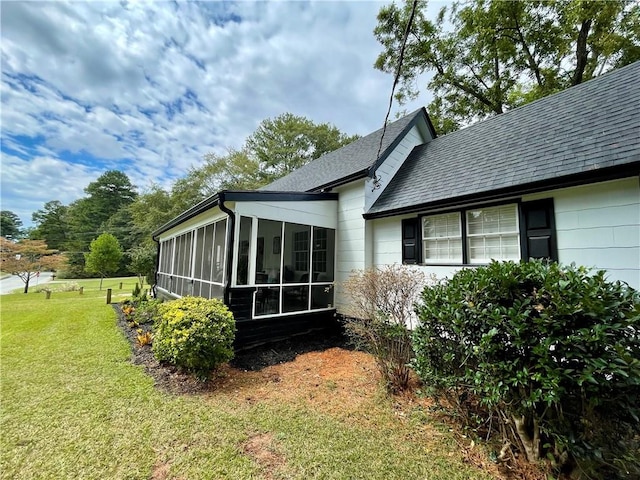 view of property exterior featuring a sunroom and a yard