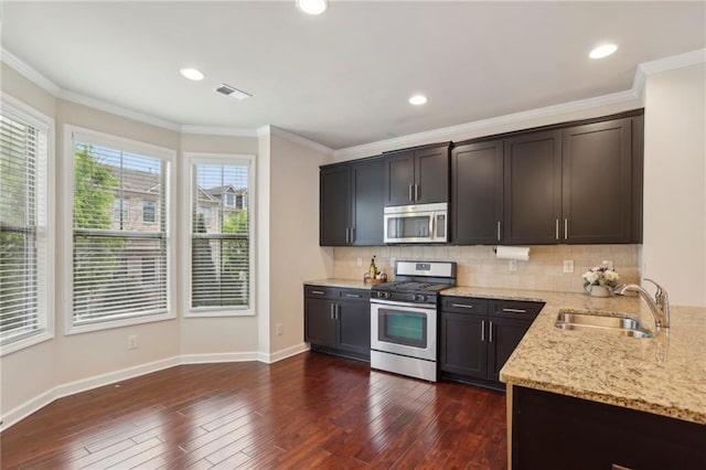 kitchen with light stone countertops, visible vents, a sink, stainless steel appliances, and tasteful backsplash