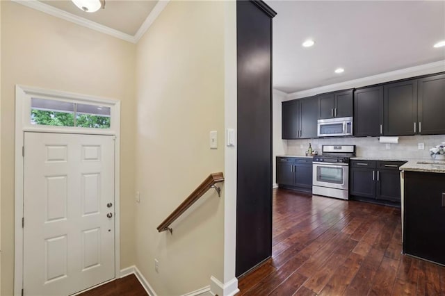 kitchen featuring light stone countertops, ornamental molding, dark wood-type flooring, tasteful backsplash, and appliances with stainless steel finishes