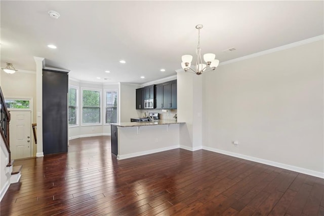kitchen featuring stainless steel microwave, crown molding, a chandelier, and stove