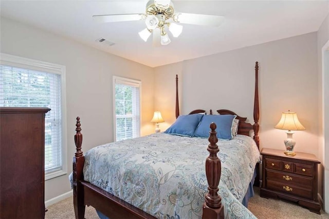 bedroom featuring a ceiling fan, visible vents, light carpet, and baseboards