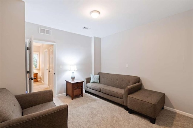 living area featuring light carpet, visible vents, and baseboards