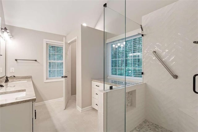 full bath with a stall shower, double vanity, a sink, and tile patterned floors