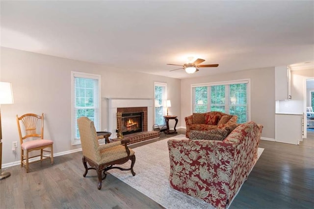 living room with a fireplace, plenty of natural light, wood finished floors, and baseboards