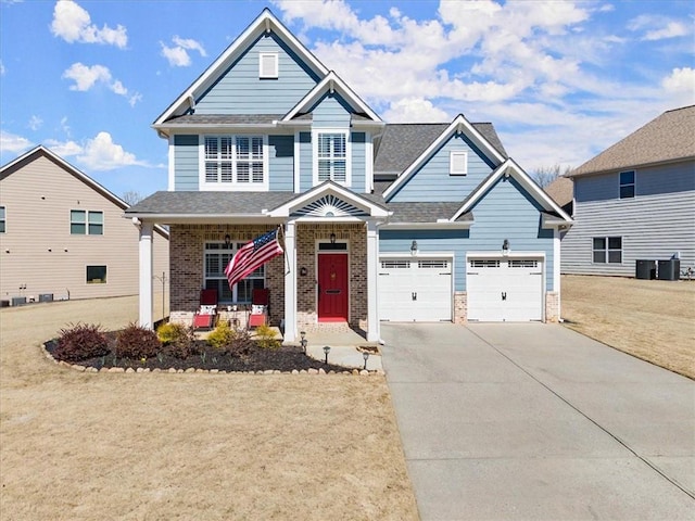 craftsman-style house featuring a shingled roof, a porch, concrete driveway, and brick siding