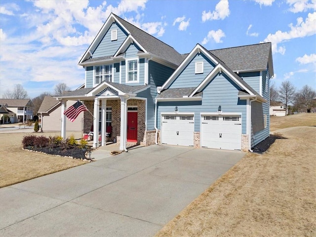 view of front of home featuring a garage, driveway, brick siding, and roof with shingles