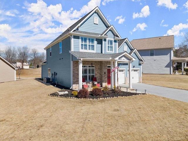 view of front facade with a garage, brick siding, concrete driveway, cooling unit, and a front yard