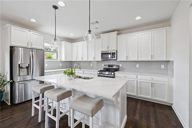 1998 Lakeview Bend Way, Buford, GA 30519 - kitchen with stainless steel appliances, white cabinets, a kitchen island with sink, backsplash, and recessed lighting