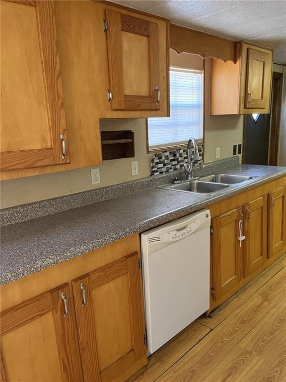 kitchen with sink, a textured ceiling, white dishwasher, and light hardwood / wood-style floors