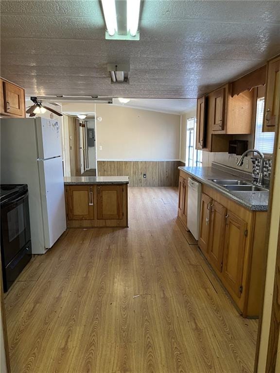 kitchen featuring sink, white appliances, light hardwood / wood-style flooring, a textured ceiling, and kitchen peninsula