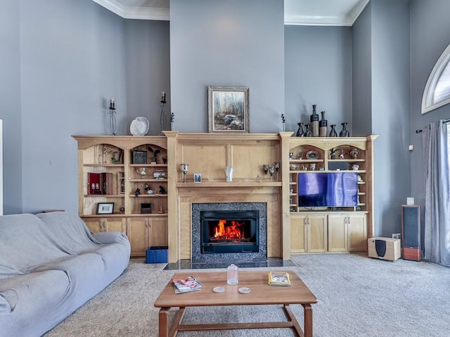 carpeted living room with a high end fireplace and ornamental molding