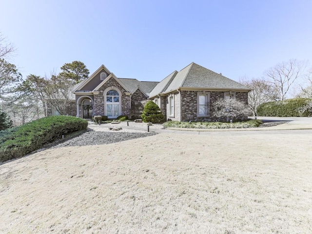 view of front of home with brick siding and a shingled roof