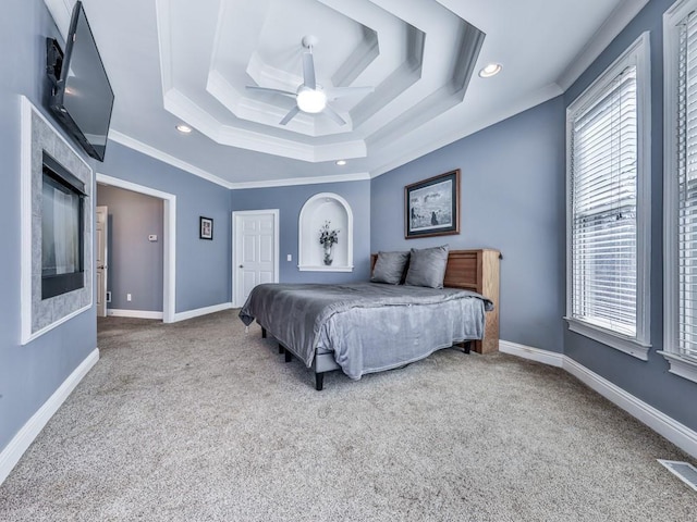 carpeted bedroom featuring visible vents, baseboards, crown molding, and a tray ceiling