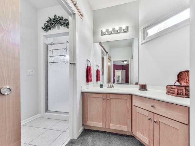 bathroom featuring vanity, baseboards, ceiling fan, a shower stall, and tile patterned floors