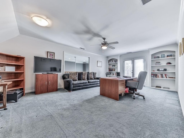 carpeted home office featuring visible vents, built in features, crown molding, lofted ceiling, and ceiling fan