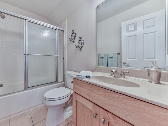 bathroom with vanity, tile patterned floors, toilet, and enclosed tub / shower combo