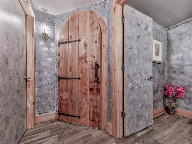 bathroom featuring wallpapered walls, wood finished floors, and baseboards