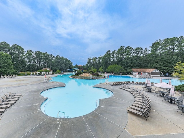 community pool featuring a patio and a water slide