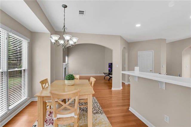1712 Bonnabel Trce NE, Marietta, GA 30066 - dining area featuring arched walkways, light wood finished floors, baseboards, a chandelier, and recessed lighting