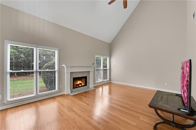 1712 Bonnabel Trce NE, Marietta, GA 30066 - unfurnished living room featuring high vaulted ceiling, light wood-style floors, a ceiling fan, a tiled fireplace, and baseboards