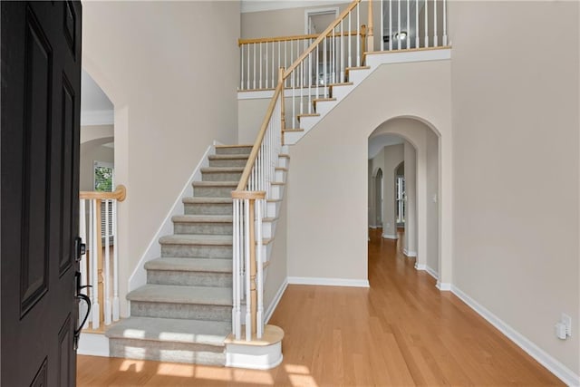 1712 Bonnabel Trce NE, Marietta, GA 30066 - foyer with arched walkways, a high ceiling, light wood-type flooring, stairway, and baseboards
