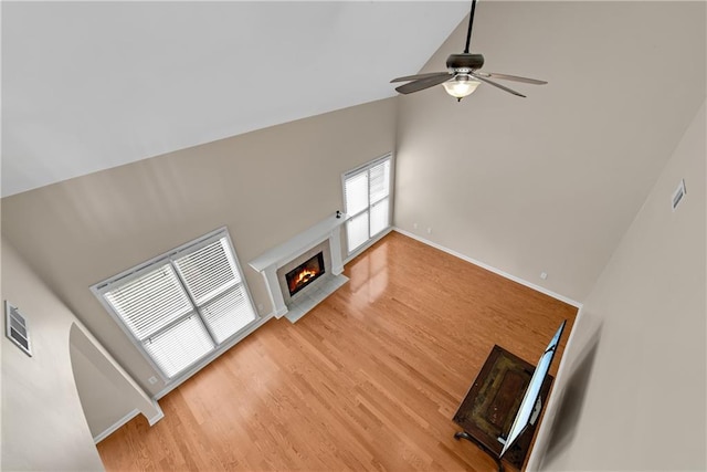 1712 Bonnabel Trce NE, Marietta, GA 30066 - unfurnished living room featuring a tiled fireplace, ceiling fan, light wood-style floors, high vaulted ceiling, and baseboards