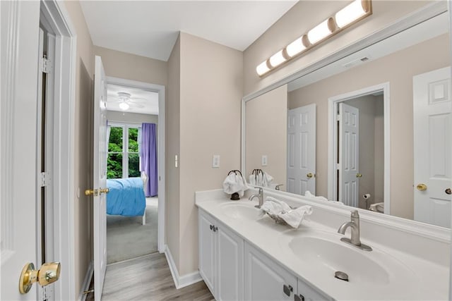 1712 Bonnabel Trce NE, Marietta, GA 30066 - full bathroom with double vanity, wood finished floors, toilet, baseboards, and a ceiling fan