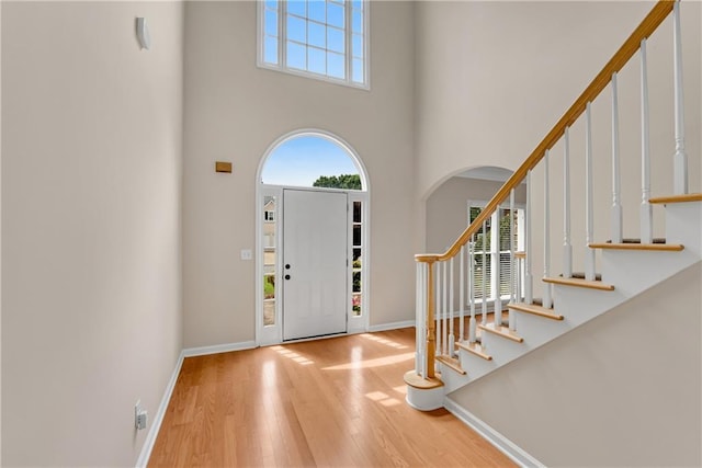 1712 Bonnabel Trce NE, Marietta, GA 30066 - entrance foyer with arched walkways, a towering ceiling, wood finished floors, stairs, and baseboards