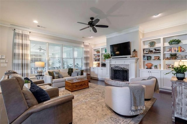 living room featuring crown molding, dark hardwood / wood-style flooring, ceiling fan, and a fireplace