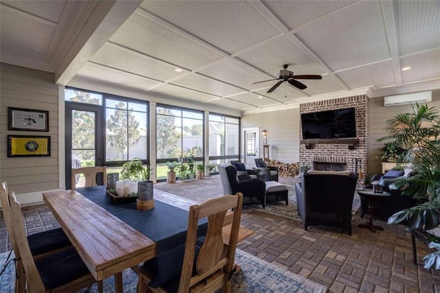 dining room with ceiling fan, a fireplace, and wood walls