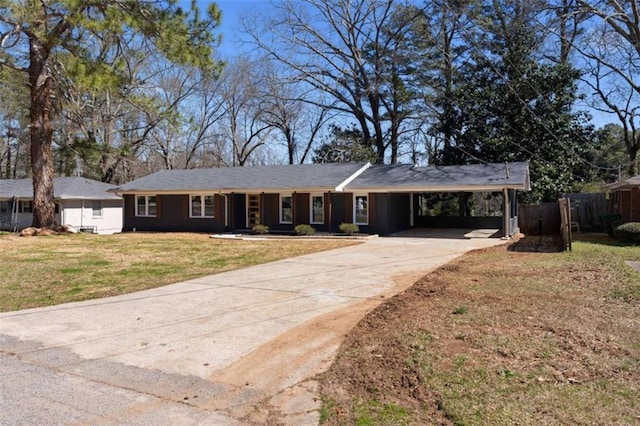 ranch-style home with a carport, concrete driveway, a front lawn, and fence