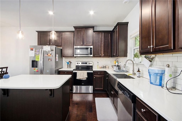 2517 Hedgeway Cir, Kennesaw, GA 30144 - kitchen featuring stainless steel appliances, a sink, a breakfast bar, dark brown cabinetry, and dark wood-style floors