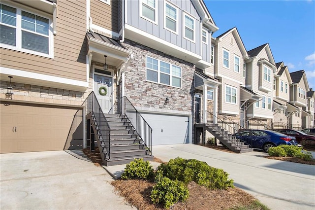 2517 Hedgeway Cir, Kennesaw, GA 30144 - view of front facade featuring a garage, stone siding, a residential view, concrete driveway, and board and batten siding