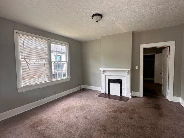 6 Hazel St, Porterdale, GA 30014 - unfurnished living room with carpet floors, a textured ceiling, and a fireplace with flush hearth