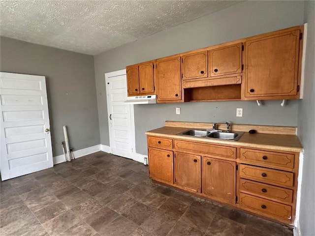 6 Hazel St, Porterdale, GA 30014 - kitchen with a textured ceiling, light countertops, brown cabinets, stone finish flooring, and under cabinet range hood