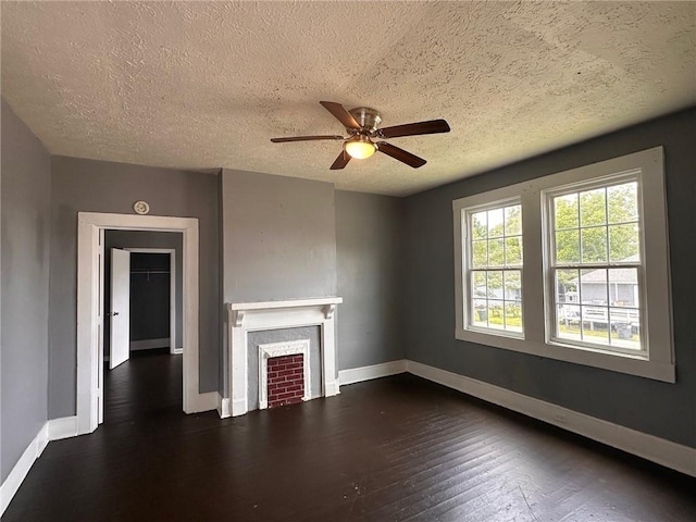 6 Hazel St, Porterdale, GA 30014 - unfurnished living room with dark wood-style flooring, a textured ceiling, a fireplace, and a ceiling fan