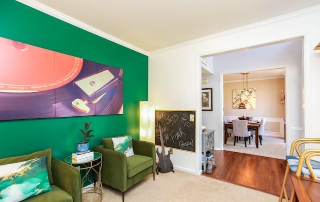 sitting room featuring carpet, a chandelier, and crown molding
