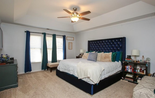 carpeted bedroom with a ceiling fan, crown molding, and a tray ceiling