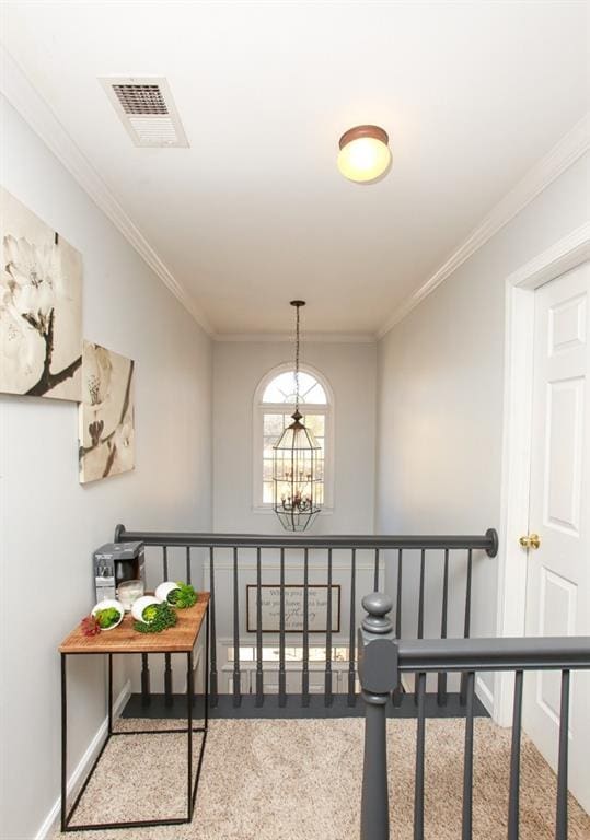 interior space featuring carpet floors, a chandelier, ornamental molding, baseboards, and visible vents
